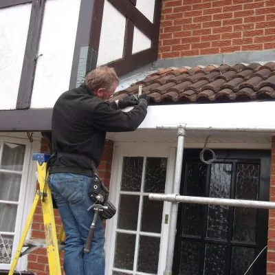 Carpenter on a ladder working on a door opening