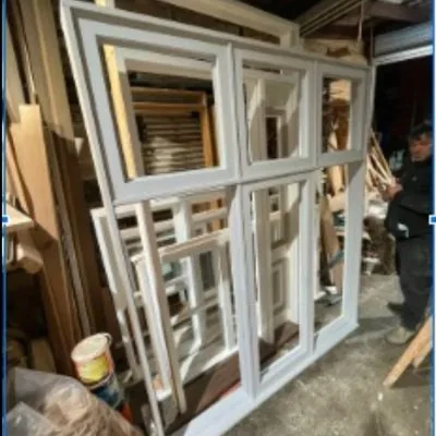 Restored window sashes stacked in the workshop